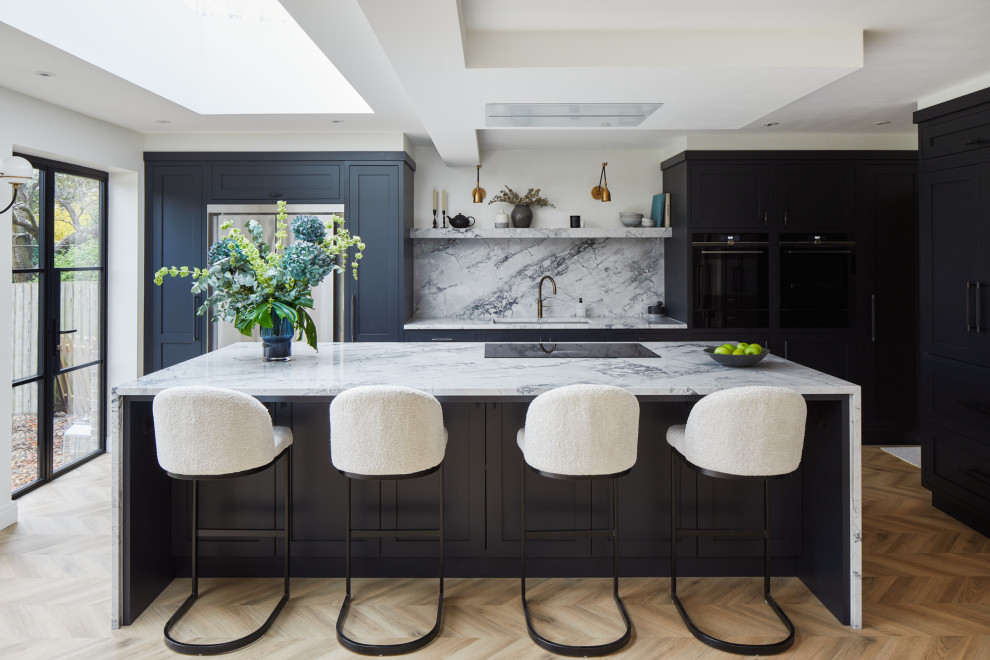 Inspiration for a large transitional l-shaped eat-in kitchen remodel in London with recessed-panel cabinets, black cabinets and an island