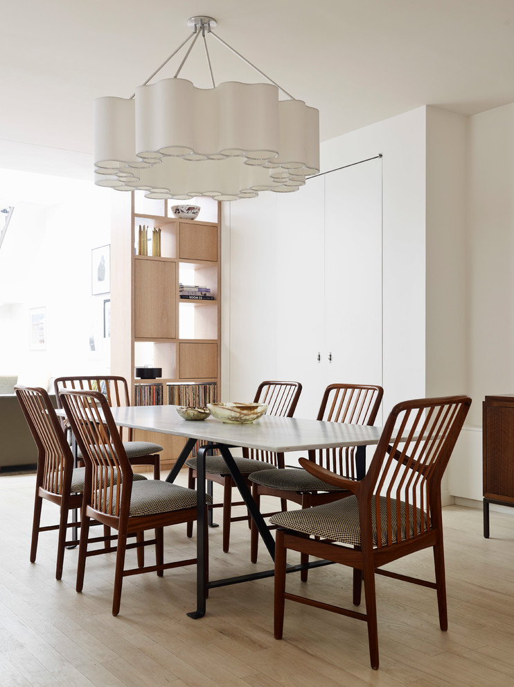 Design ideas for a contemporary dining room in New York with white walls, light hardwood floors and beige floor.
