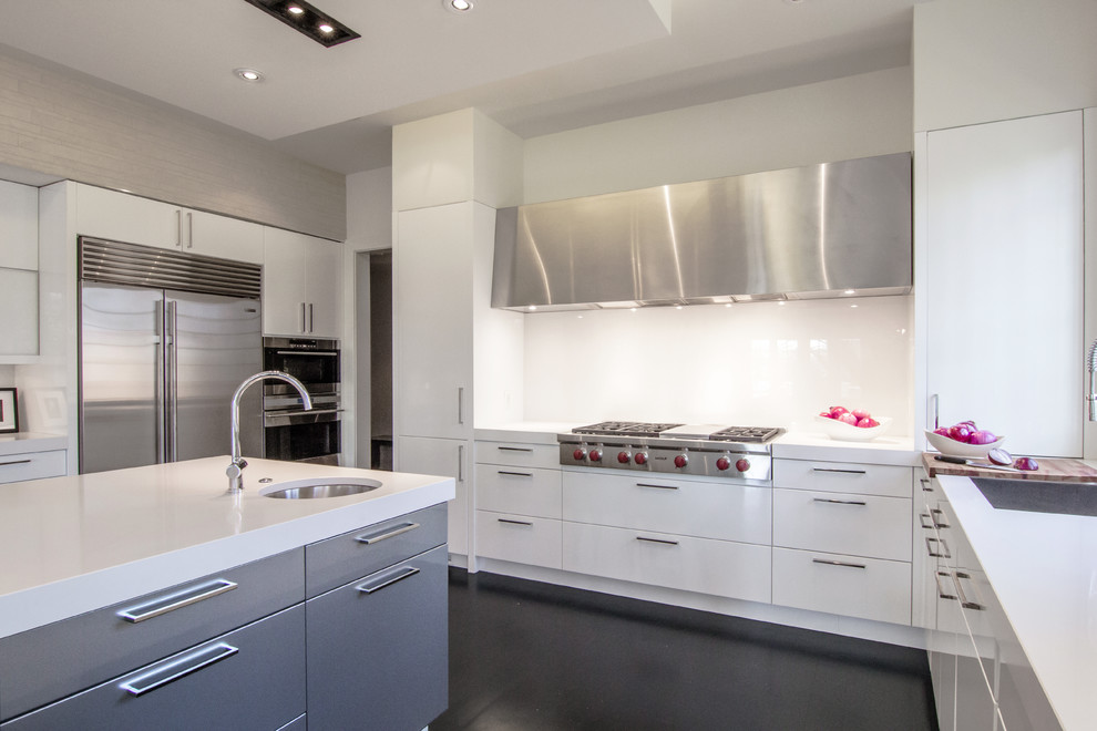 Mid-sized modern u-shaped eat-in kitchen in DC Metro with an undermount sink, flat-panel cabinets, white cabinets, solid surface benchtops, stainless steel appliances, dark hardwood floors, with island, metallic splashback, mirror splashback and black floor.