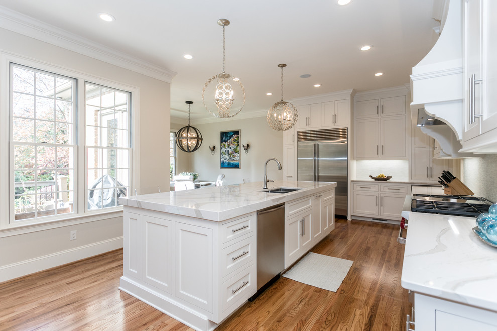 Inspiration for a light wood floor eat-in kitchen remodel with a double-bowl sink, quartz countertops, stainless steel appliances, an island and white countertops