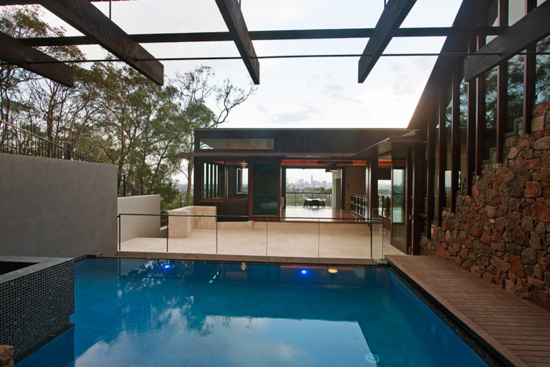 Design ideas for a mid-sized contemporary courtyard rectangular infinity pool in Brisbane with a hot tub and tile.