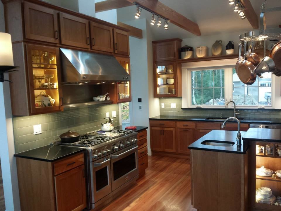 Inspiration for a large transitional medium tone wood floor and brown floor kitchen remodel with shaker cabinets, medium tone wood cabinets, soapstone countertops, stainless steel appliances and black countertops