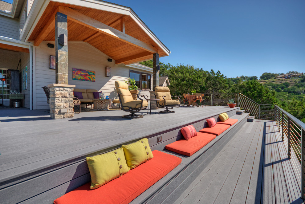 This is an example of an expansive eclectic backyard deck in Austin with a roof extension.