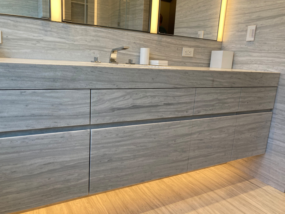 Medium sized modern cloakroom in New York with flat-panel cabinets, white cabinets, a one-piece toilet, grey tiles, marble tiles, grey walls, marble flooring, a submerged sink, marble worktops, grey floors, grey worktops, a floating vanity unit, a drop ceiling and panelled walls.