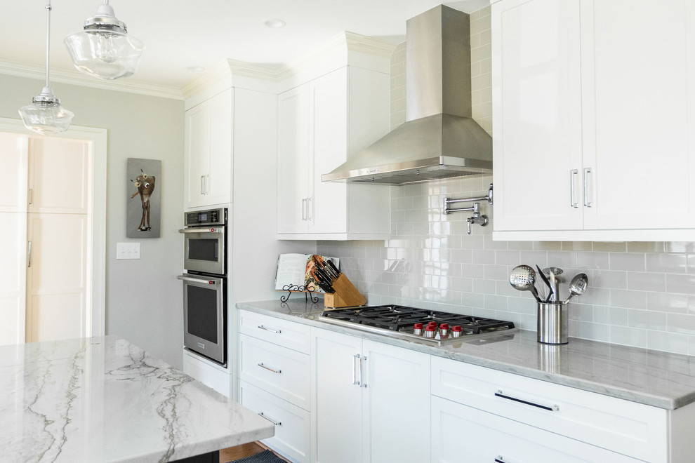 Inspiration for a transitional eat-in kitchen remodel with white cabinets, quartzite countertops, subway tile backsplash and an island
