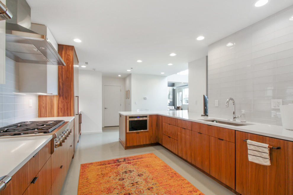 Photo of a large contemporary single-wall eat-in kitchen in Detroit with shaker cabinets, white cabinets, marble benchtops, white splashback, stainless steel appliances, with island and white benchtop.