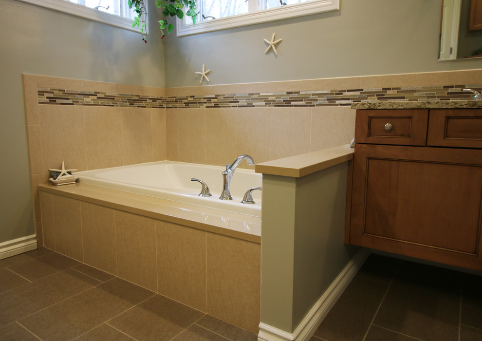 Mid-sized transitional master beige tile and porcelain tile porcelain tile drop-in bathtub photo in Detroit with flat-panel cabinets, light wood cabinets, a one-piece toilet, green walls, an undermount sink and quartz countertops