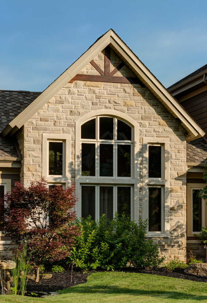Large contemporary two-storey white exterior in Other with stone veneer and a gable roof.