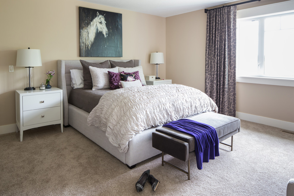 This is an example of a large traditional master bedroom in Calgary with beige walls and carpet.