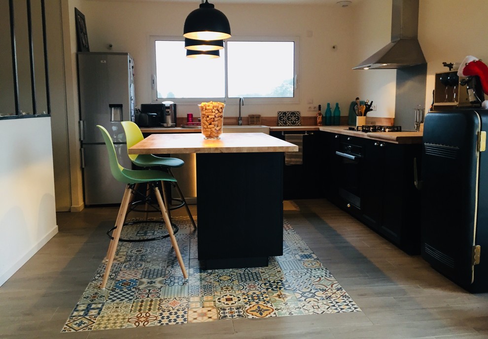 Inspiration for a mid-sized midcentury l-shaped eat-in kitchen in Montpellier with a drop-in sink, beaded inset cabinets, black cabinets, laminate benchtops, brown splashback, cement tile splashback, panelled appliances, cement tiles, with island, multi-coloured floor and brown benchtop.