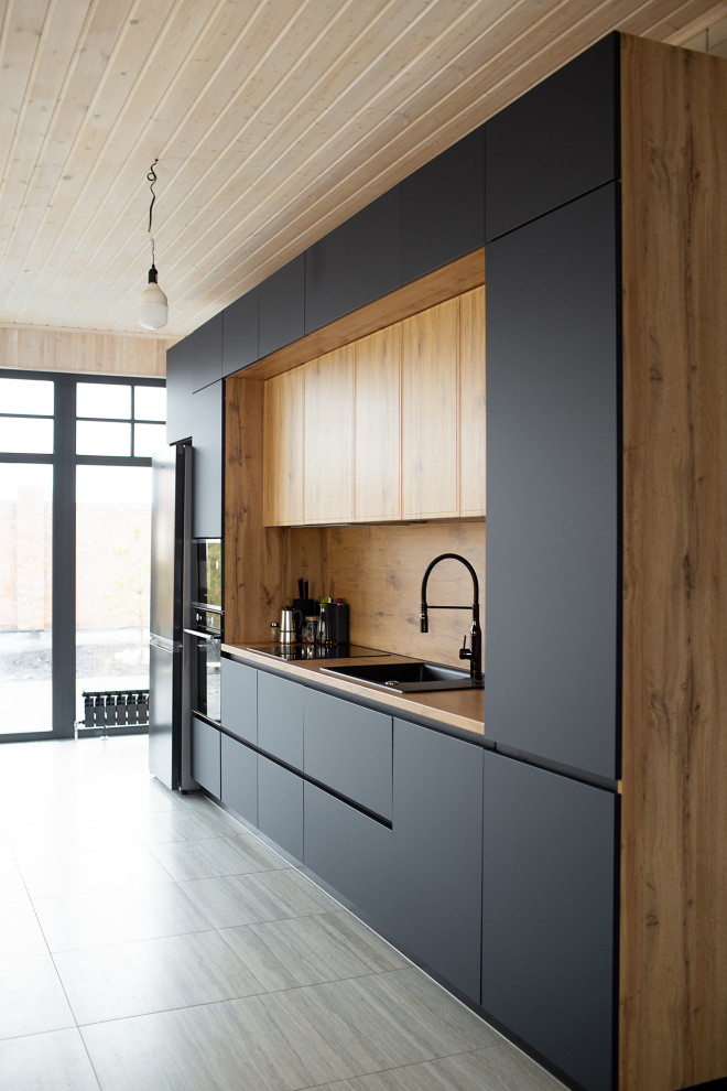 Photo of a large urban grey and white single-wall kitchen/diner in Other with a submerged sink, flat-panel cabinets, black cabinets, laminate countertops, brown splashback, all types of splashback, black appliances, laminate floors, an island, beige floors, brown worktops and a timber clad ceiling.