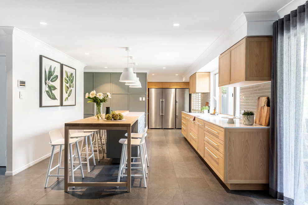 Design ideas for a mid-sized transitional l-shaped kitchen in Brisbane with an undermount sink, shaker cabinets, medium wood cabinets, grey splashback, glass tile splashback, stainless steel appliances, with island, beige floor and white benchtop.