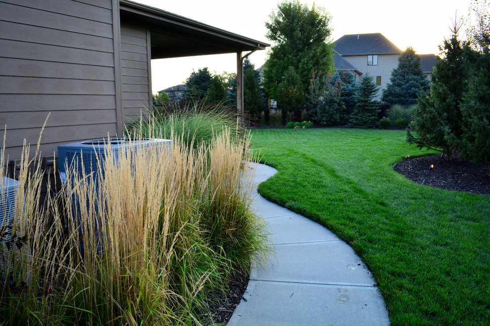 Inspiration for a mid-sized rustic shade front yard concrete paver landscaping in Omaha.