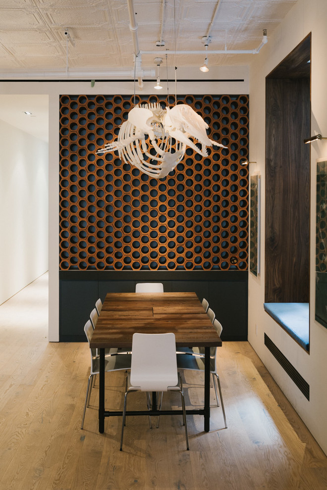 Mid-sized trendy medium tone wood floor great room photo in New York with white walls and no fireplace