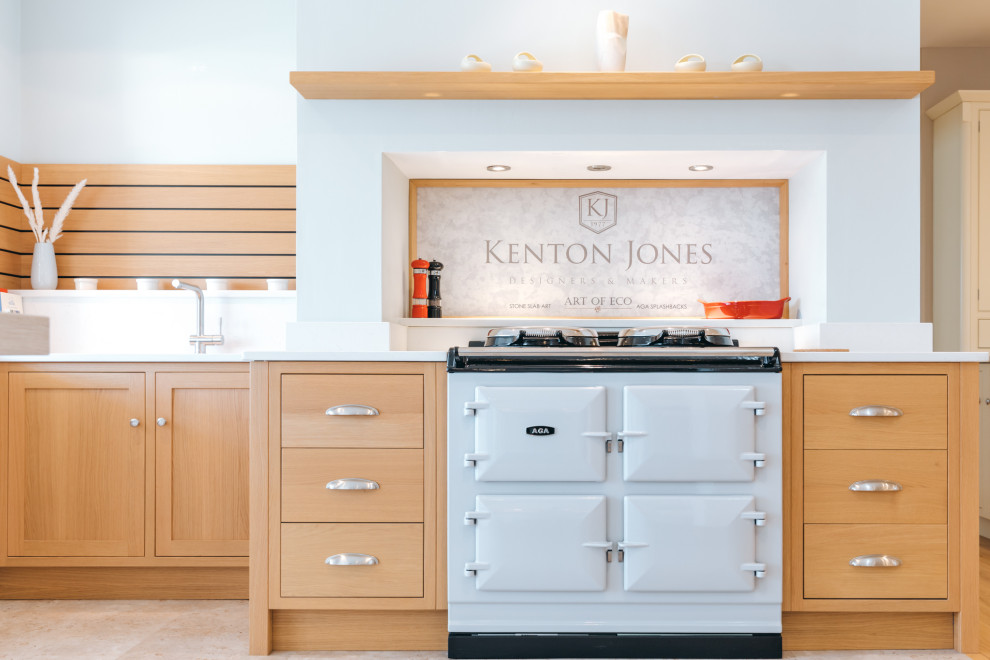 Small traditional l-shaped enclosed kitchen with a submerged sink, stone slab splashback, limestone flooring, beige floors, shaker cabinets, quartz worktops, white splashback, coloured appliances, a breakfast bar, white worktops and a chimney breast.