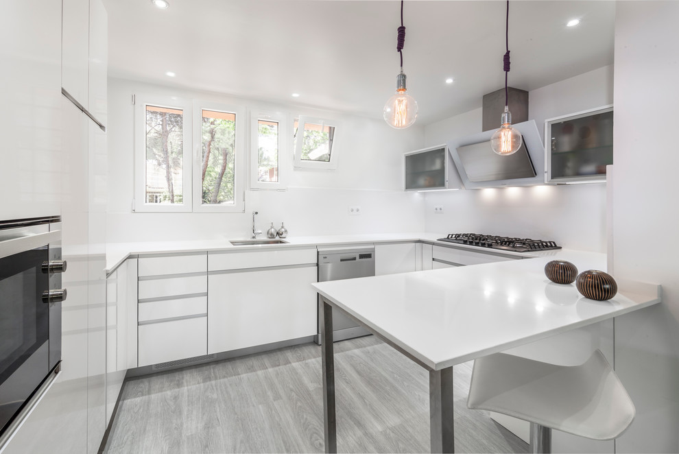 Inspiration for a mid-sized contemporary u-shaped eat-in kitchen in Madrid with an undermount sink, flat-panel cabinets, white cabinets, white splashback, stainless steel appliances, painted wood floors and a peninsula.