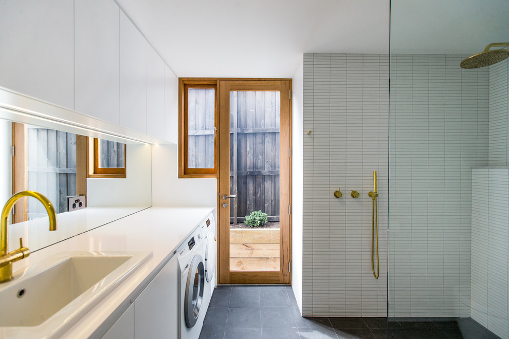 Photo of a mid-sized contemporary 3/4 wet room bathroom in Sydney with flat-panel cabinets, white cabinets, white tile, white walls, concrete floors, a drop-in sink, black floor, an open shower, white benchtops and a laundry.