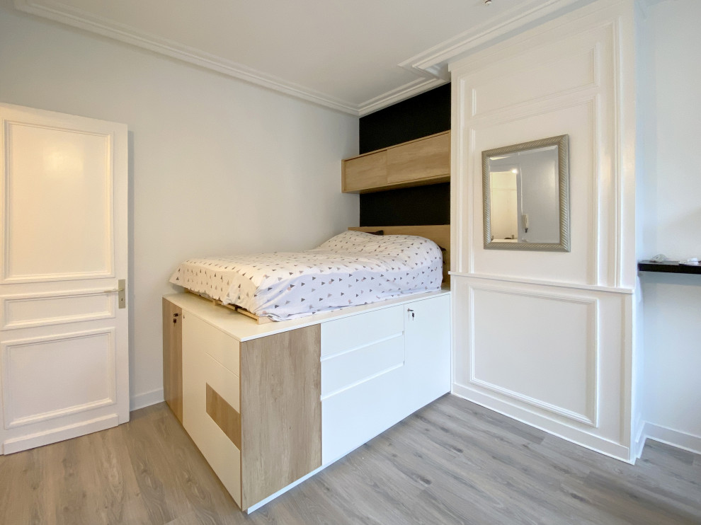 Idee per una piccola camera da letto contemporanea con pareti bianche, parquet chiaro, camino classico, pavimento grigio e boiserie