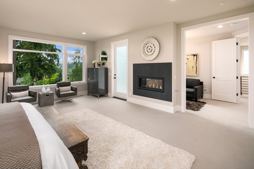 This is an example of a large contemporary master bedroom in Seattle with carpet, a two-sided fireplace, a metal fireplace surround and wallpaper.