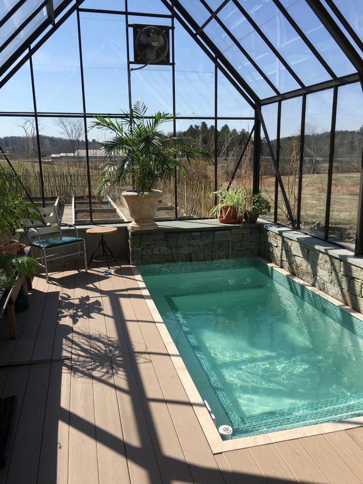 This is an example of a small modern backyard rectangular lap pool in Burlington with a water feature and decking.