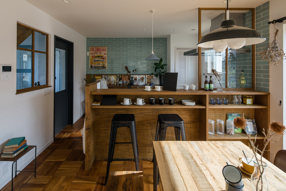 Photo of a small contemporary single-wall open plan kitchen in Other with open cabinets, medium wood cabinets, solid surface benchtops, white splashback, light hardwood floors, with island, brown floor, white benchtop and wallpaper.