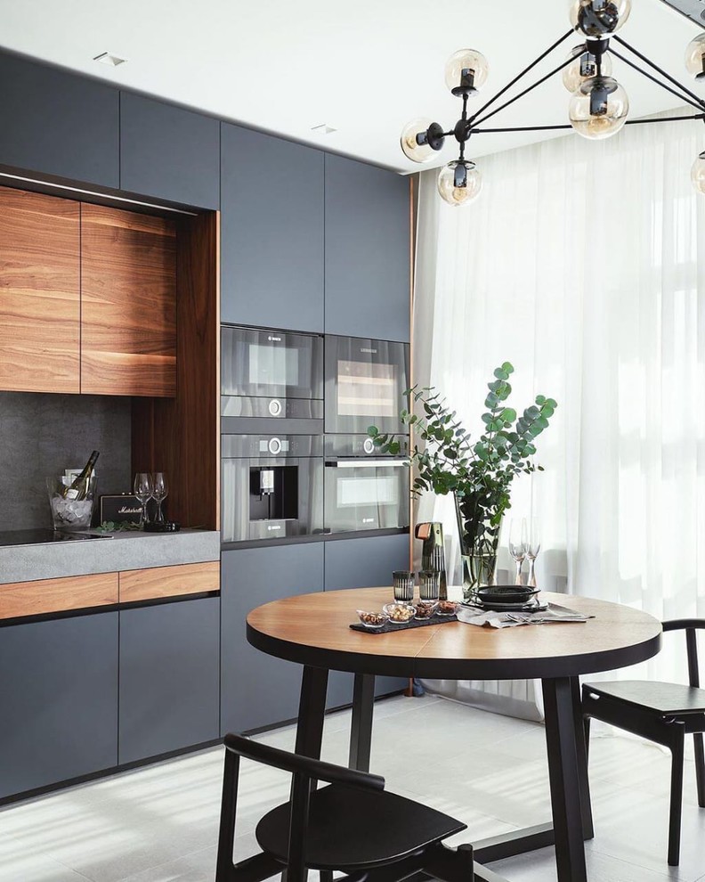 Mid-sized contemporary eat-in kitchen in Moscow with flat-panel cabinets, grey cabinets, grey splashback, black appliances, white floor and grey benchtop.