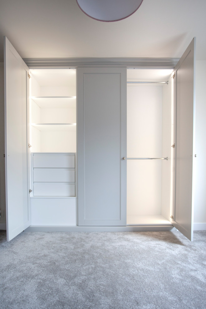 Réalisation d'une armoire encastrée minimaliste de taille moyenne et neutre avec un placard à porte shaker, des portes de placard grises et moquette.