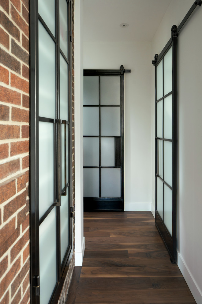 Photo of a modern hallway in Denver with white walls and dark hardwood floors.
