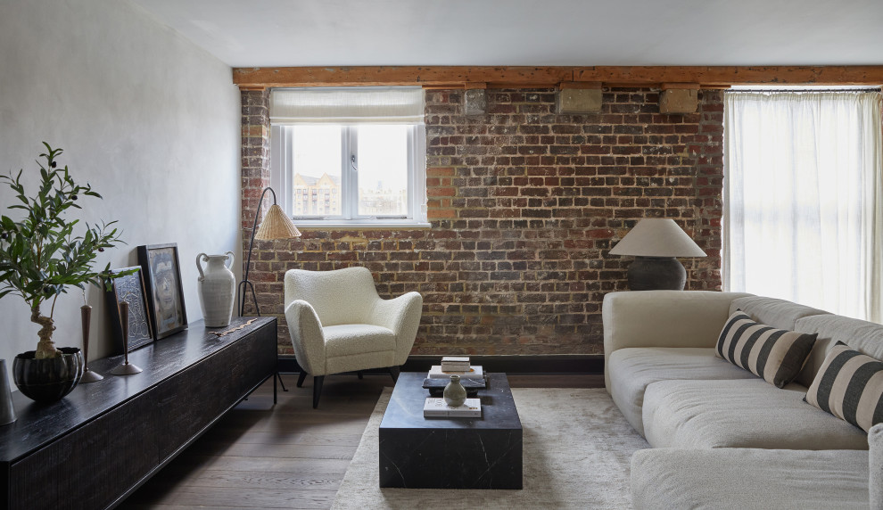 Inspiration for an urban living room in London with white walls, dark hardwood flooring, brown floors and brick walls.