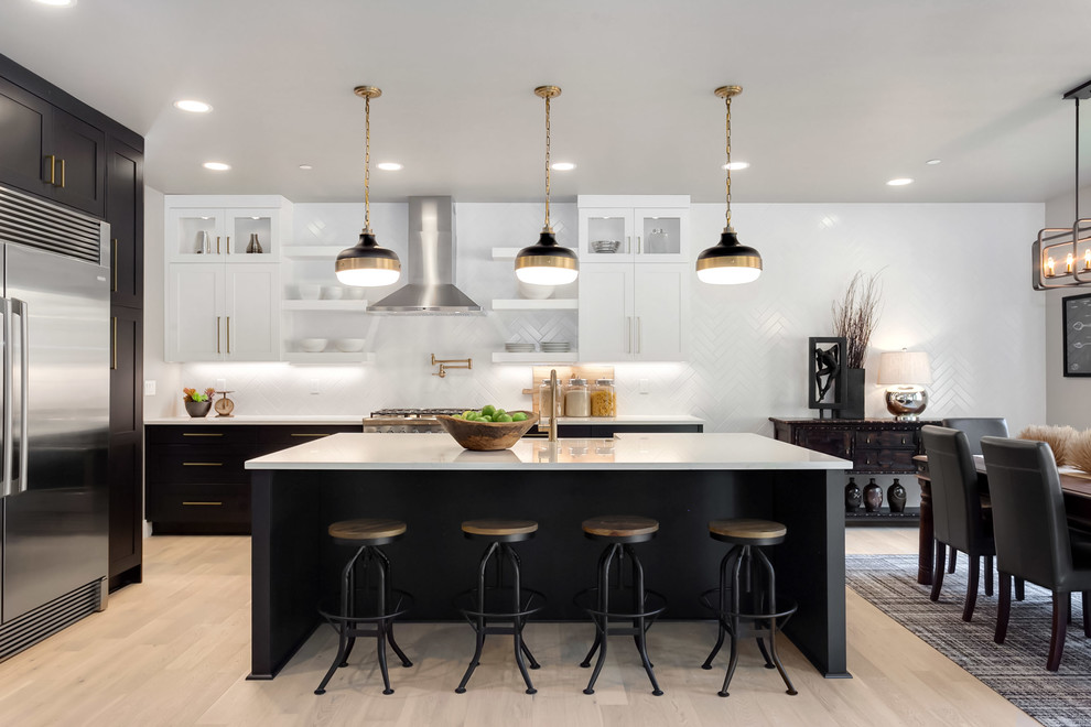 Transitional eat-in kitchen in Seattle with shaker cabinets, white cabinets, white splashback, stainless steel appliances, light hardwood floors, with island, beige floor and white benchtop.
