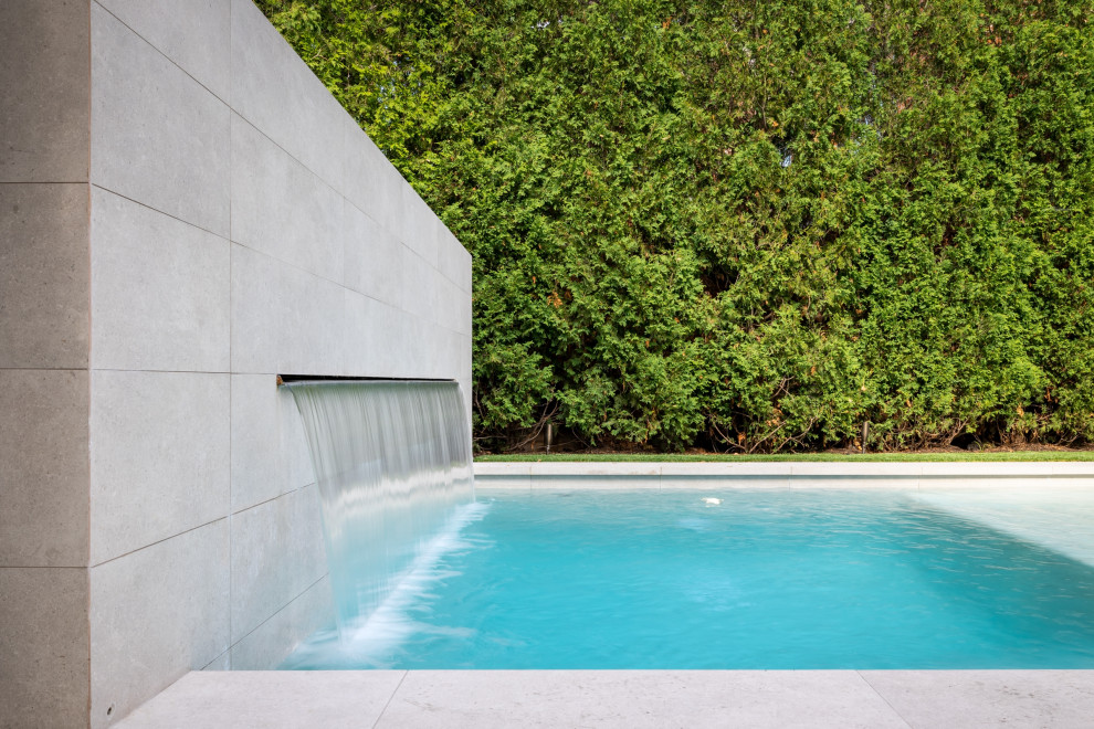 Aménagement d'un petit piscine avec aménagement paysager latéral classique rectangle avec des pavés en pierre naturelle.
