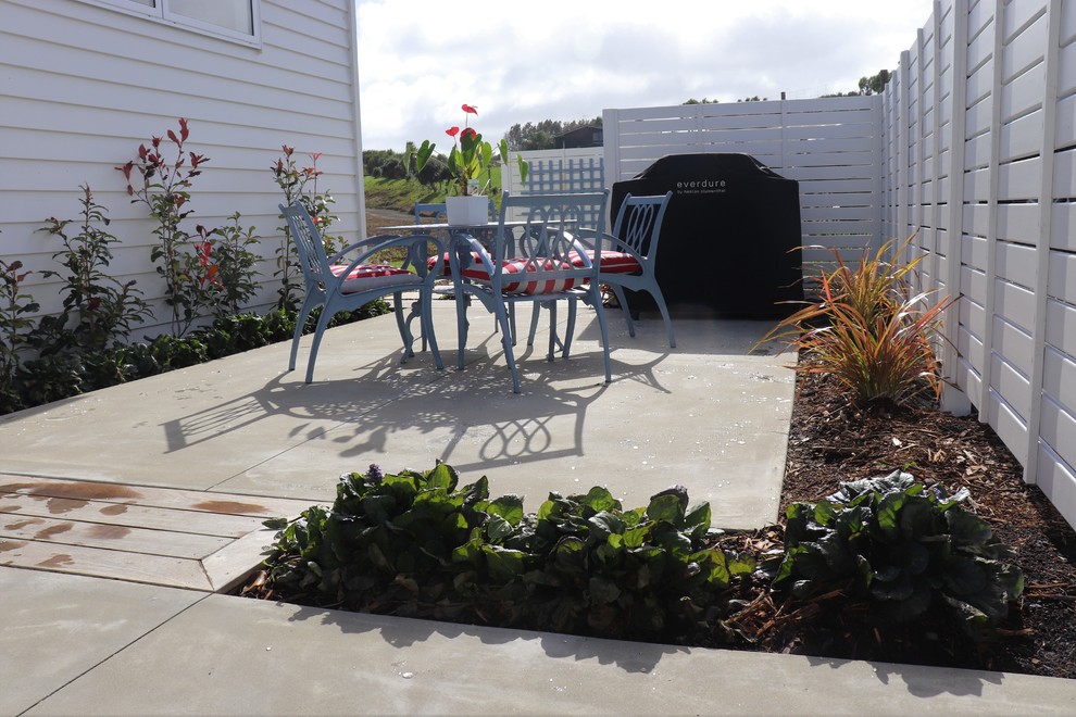 Inspiration for a large contemporary sloped full sun xeriscape in Auckland with decking.