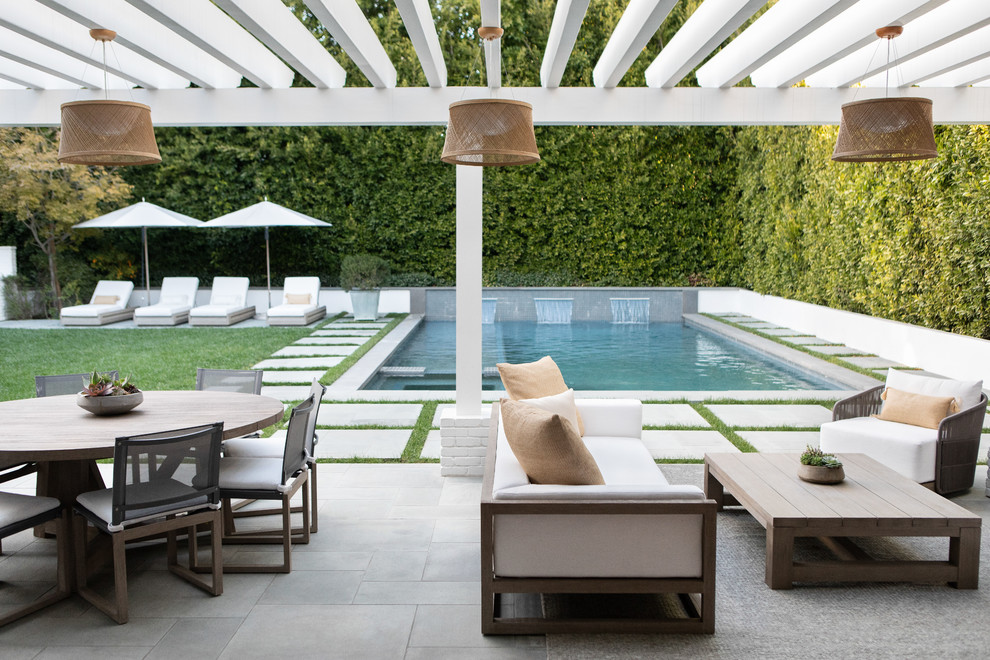 Inspiration for a large transitional backyard patio in New York with concrete pavers and a pergola.
