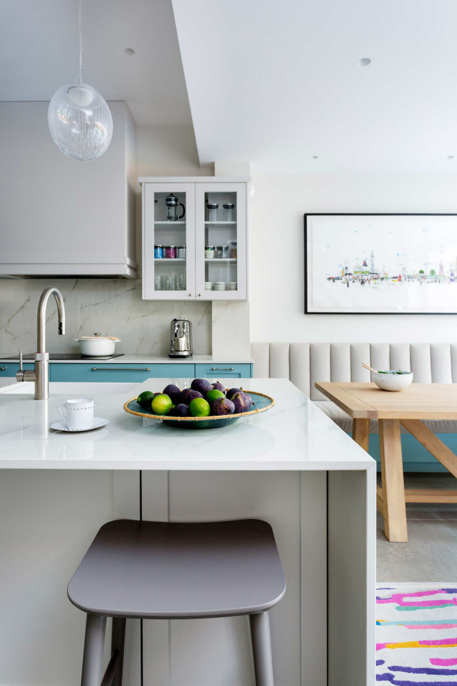 Cette photo montre une grande cuisine tendance avec un placard à porte shaker, plan de travail en marbre, une crédence en marbre et îlot.