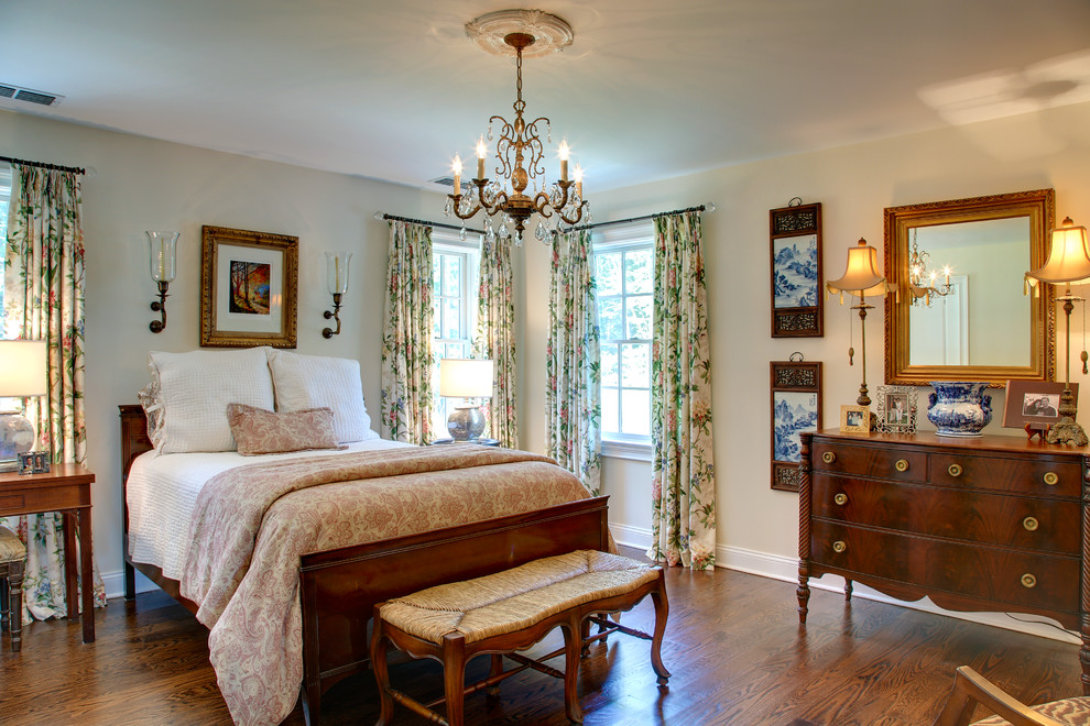 Elegant medium tone wood floor bedroom photo in Bridgeport with beige walls