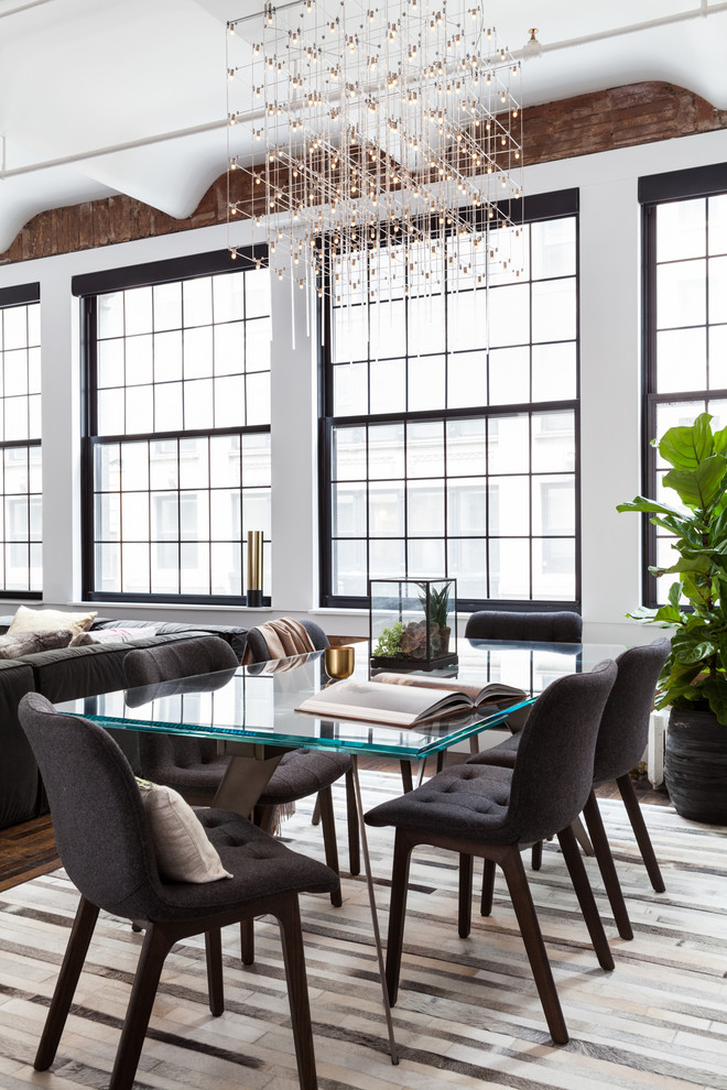 Industrial open plan dining in New York with white walls, dark hardwood floors and brown floor.