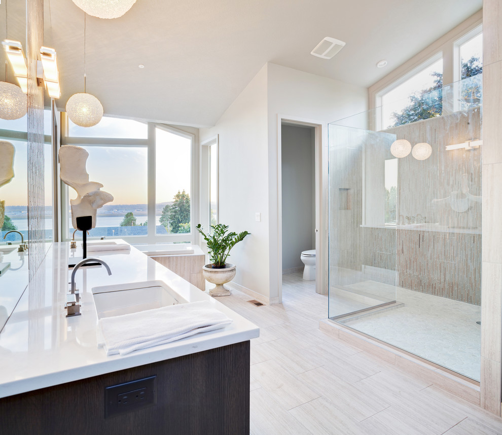 Photo of a beach style master bathroom in San Francisco with dark wood cabinets, a drop-in tub, a corner shower, a one-piece toilet, beige tile, beige walls, an undermount sink, beige floor and an open shower.