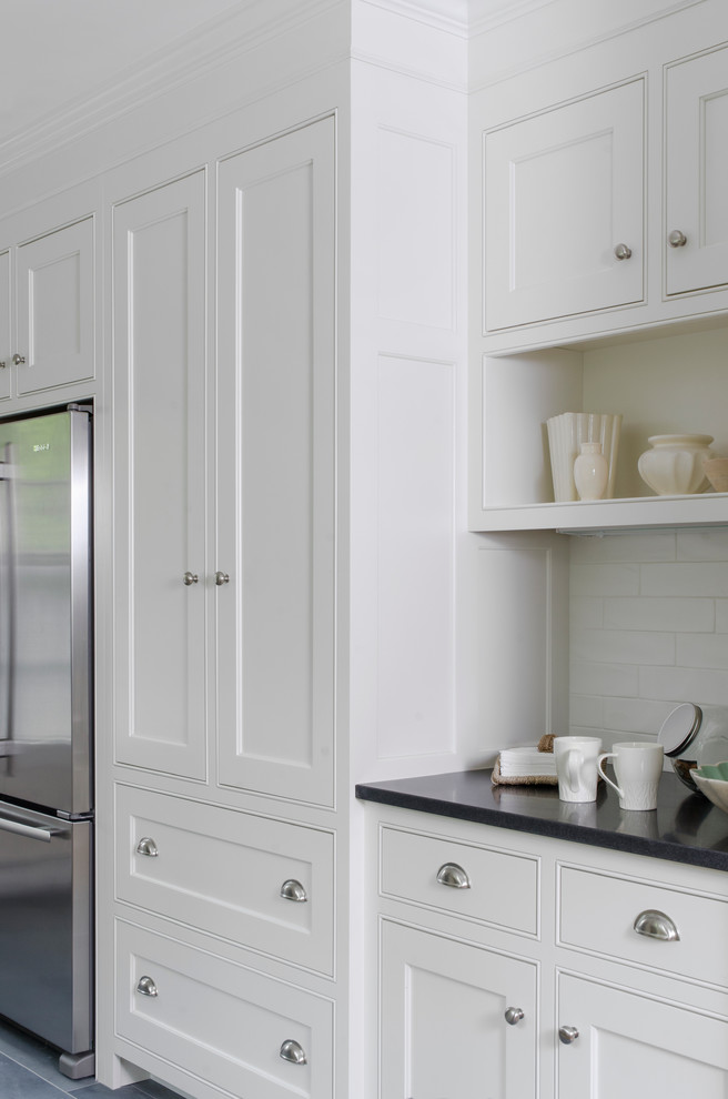 Inspiration for a mid-sized country galley eat-in kitchen in Boston with recessed-panel cabinets, white cabinets, granite benchtops, ceramic splashback, stainless steel appliances, porcelain floors, a peninsula and white splashback.