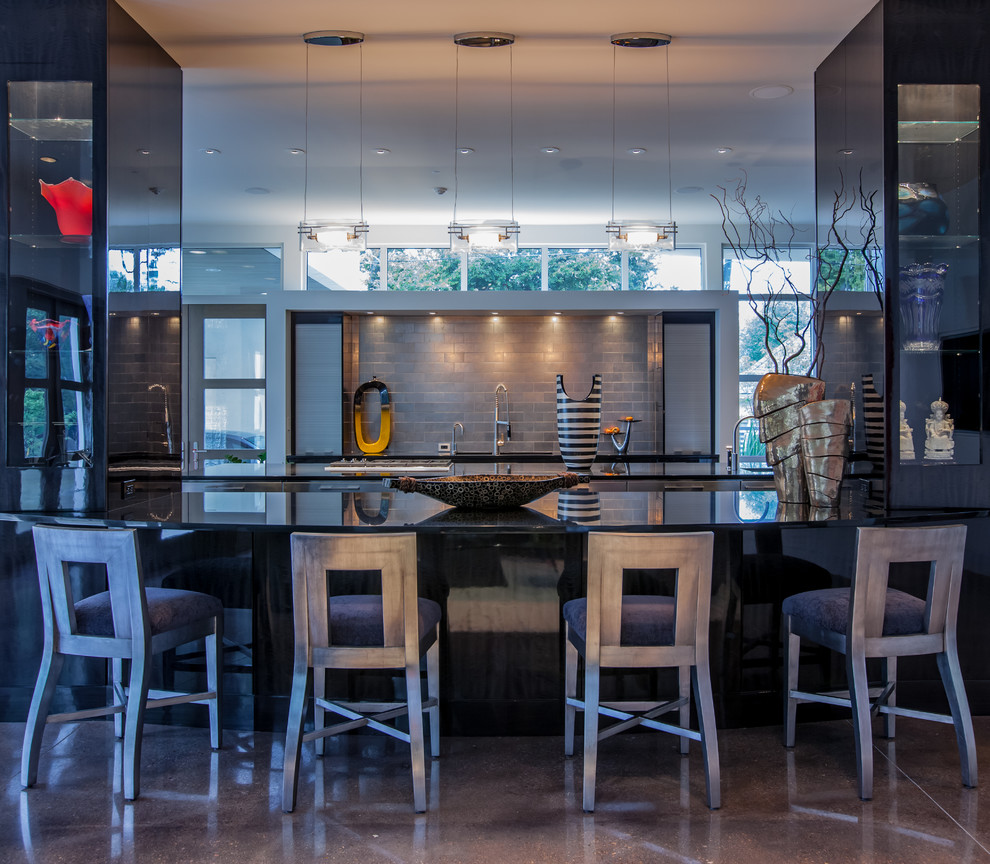 Expansive contemporary galley open plan kitchen in Dallas with metallic splashback, dark wood cabinets, granite benchtops, subway tile splashback, flat-panel cabinets, panelled appliances and concrete floors.