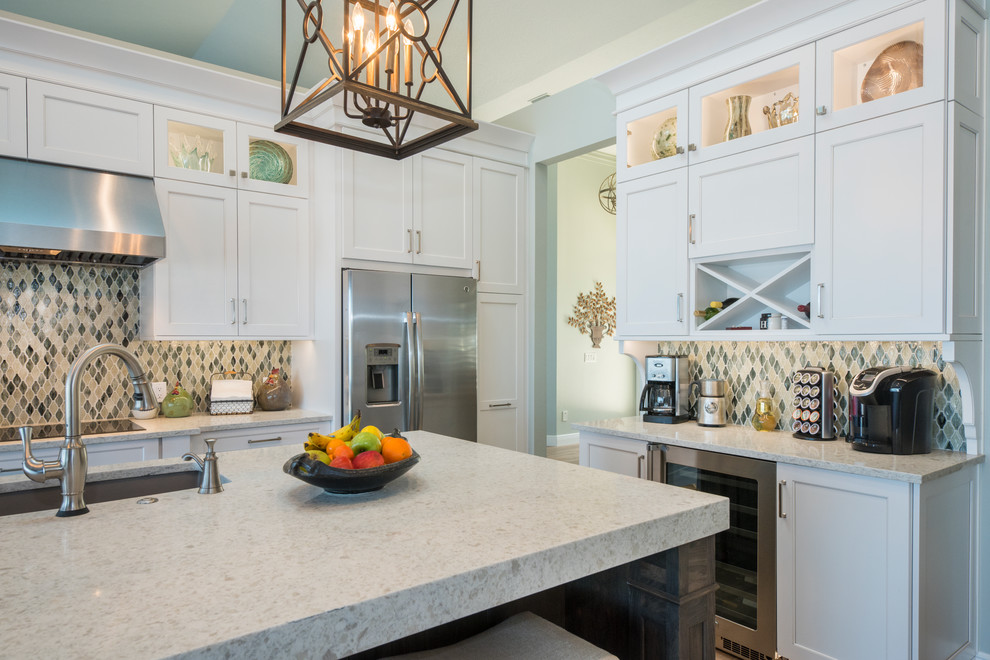 Design ideas for a large transitional l-shaped eat-in kitchen in Orlando with an undermount sink, shaker cabinets, white cabinets, quartzite benchtops, multi-coloured splashback, glass tile splashback, stainless steel appliances, medium hardwood floors, with island and brown floor.
