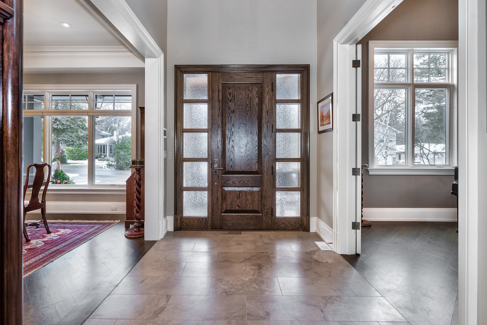 Large transitional porcelain tile and beige floor foyer photo in Toronto with gray walls and a dark wood front door