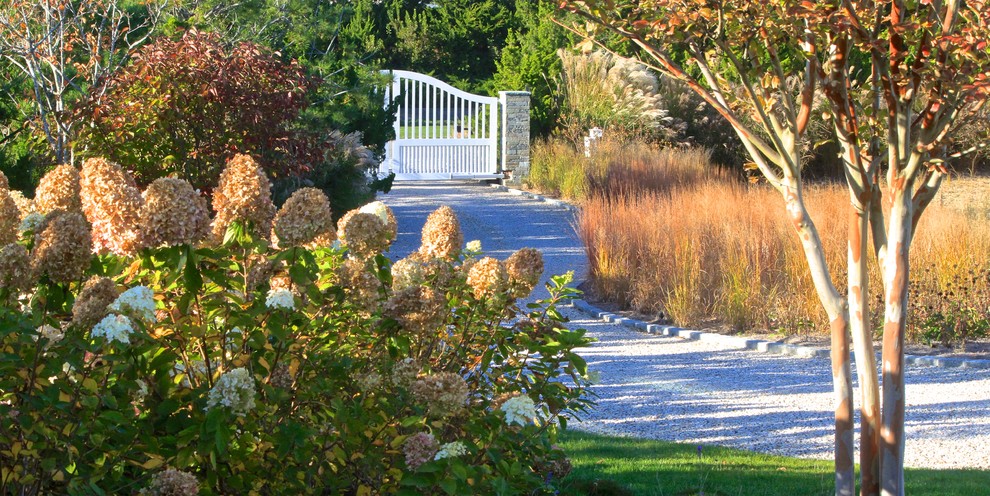 Expansive traditional front yard driveway in New York with a garden path and gravel.