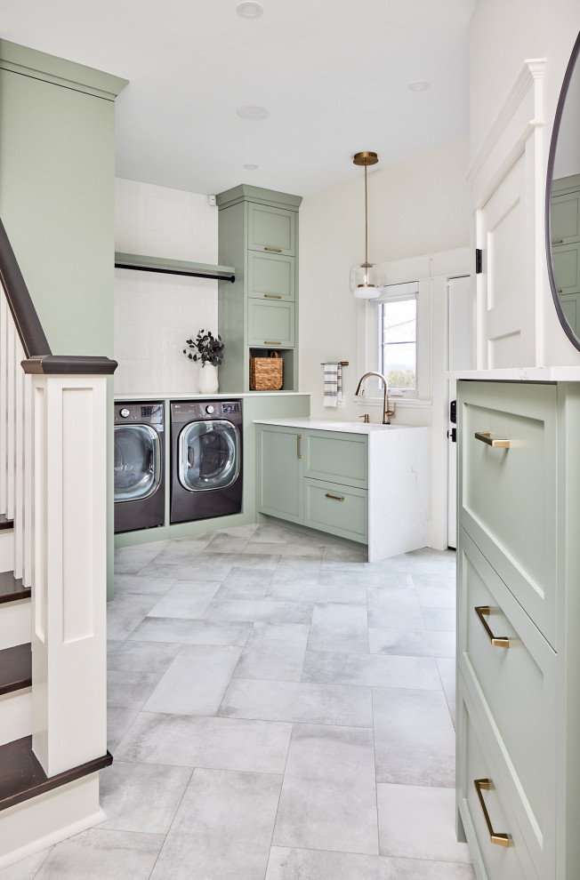 Inspiration for a mid-sized transitional porcelain tile and gray floor utility room remodel with an undermount sink, green cabinets, quartz countertops, white backsplash, ceramic backsplash, beige walls, a side-by-side washer/dryer and white countertops