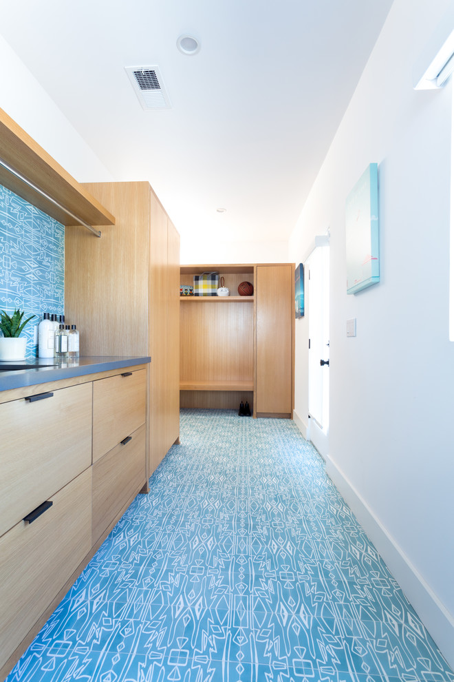 This is an example of a large midcentury single-wall laundry room in Los Angeles with an undermount sink, flat-panel cabinets, light wood cabinets, quartz benchtops, blue walls, light hardwood floors, a side-by-side washer and dryer and grey benchtop.