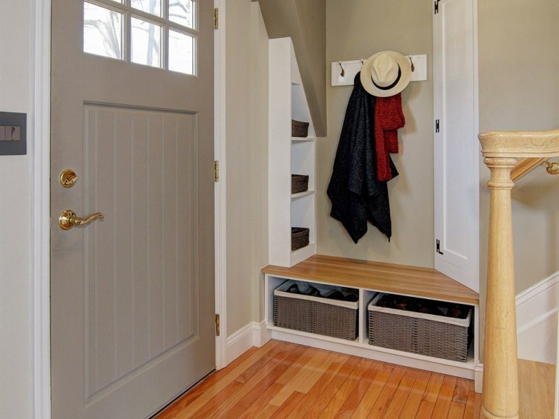 Small transitional light wood floor and brown floor mudroom photo in Newark with beige walls and a gray front door