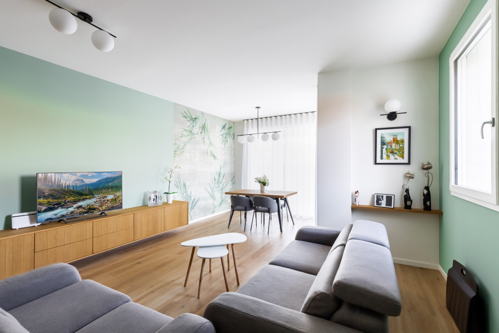 Exemple d'un très grand salon tendance fermé avec un mur vert, un sol en carrelage de porcelaine, un téléviseur fixé au mur et du papier peint.