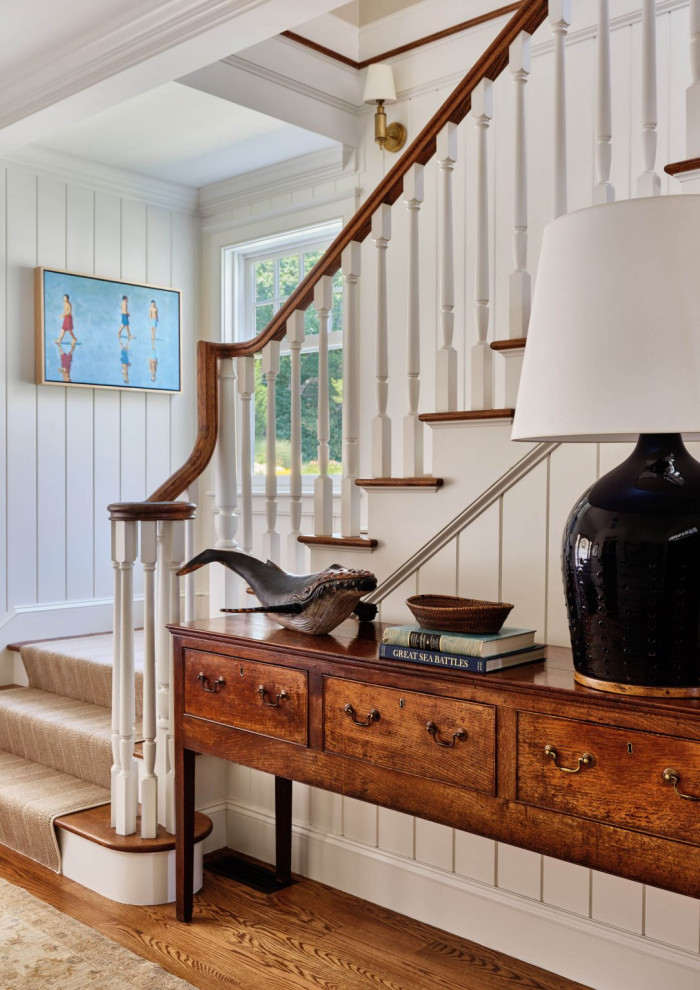 Beach style wood staircase in Boston with painted wood risers, wood railing and planked wall panelling.