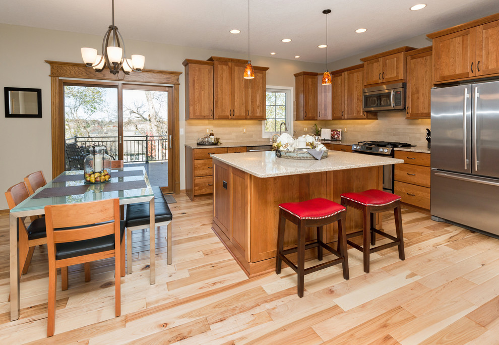 Inspiration for a mid-sized transitional l-shaped light wood floor open concept kitchen remodel with an undermount sink, recessed-panel cabinets, medium tone wood cabinets, quartz countertops, beige backsplash, stone tile backsplash, stainless steel appliances and an island