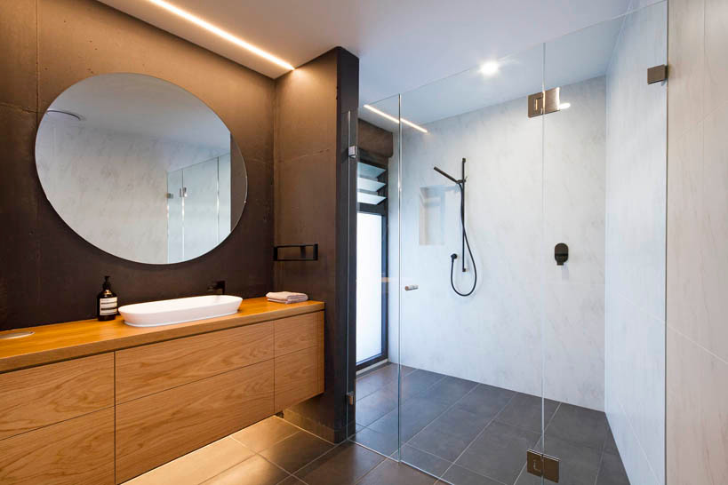 Photo of a large contemporary master bathroom in Brisbane with flat-panel cabinets, light wood cabinets, a freestanding tub, an alcove shower, a two-piece toilet, ceramic tile, grey walls, ceramic floors, a vessel sink, wood benchtops, grey floor, a hinged shower door and brown benchtops.