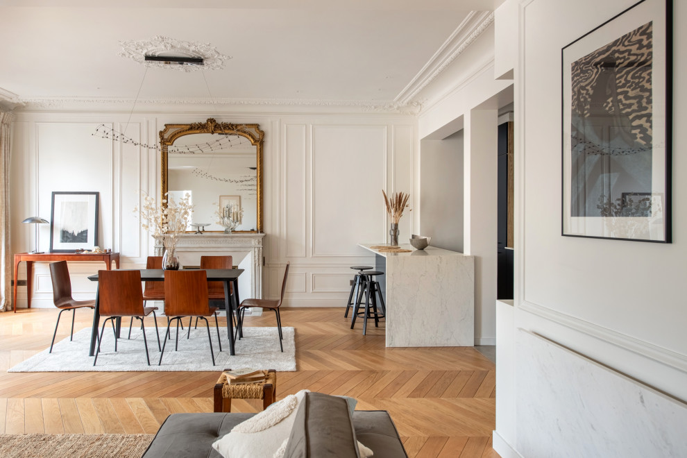 Offenes Klassisches Esszimmer mit weißer Wandfarbe, braunem Holzboden, braunem Boden und Wandpaneelen in Paris